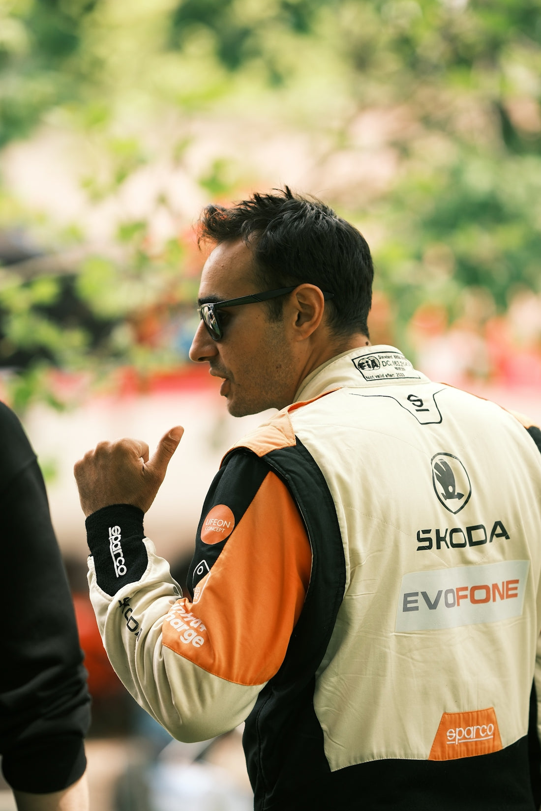 a man in a white and black jacket and sunglasses