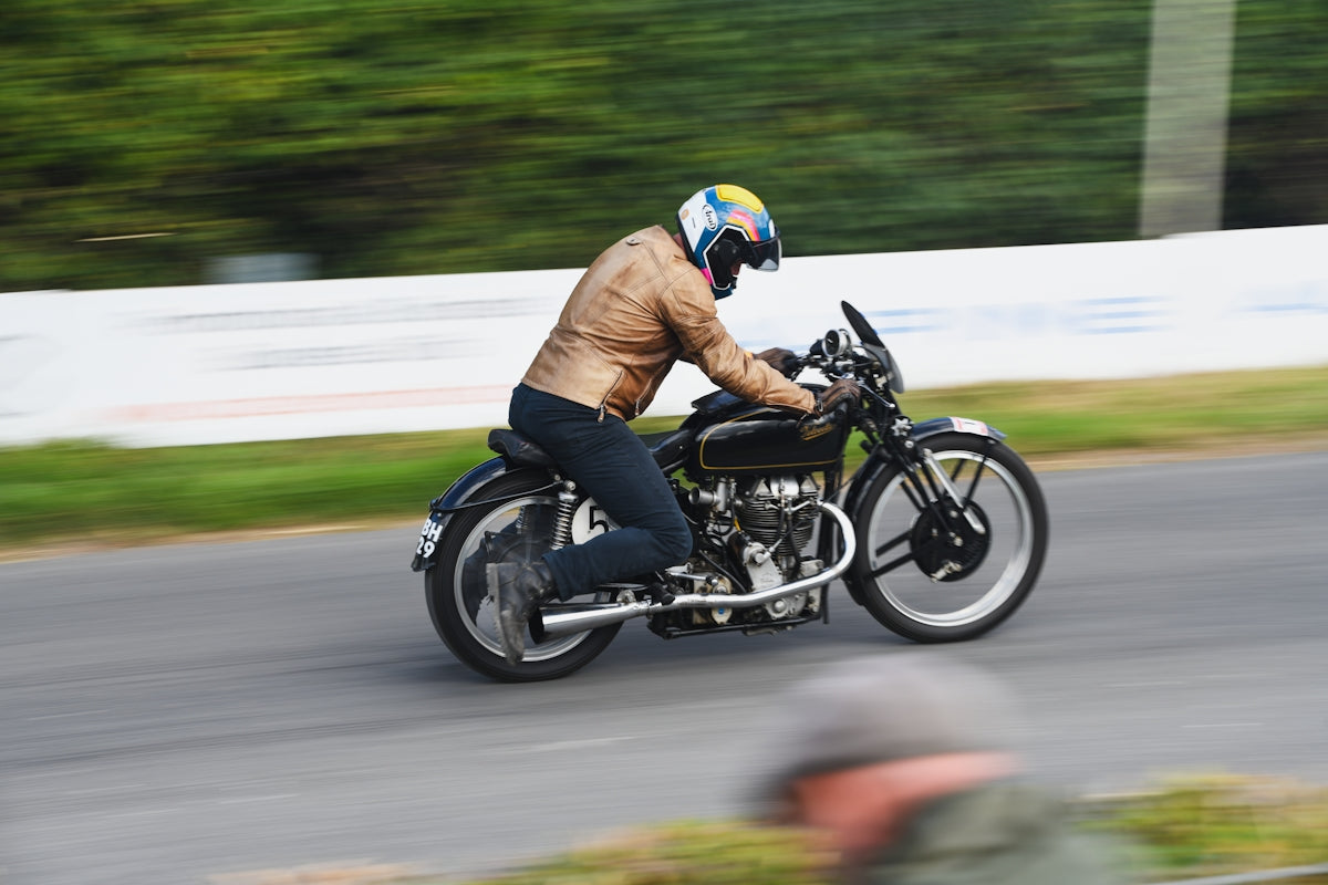 Man riding a vintage motorcycle on a track